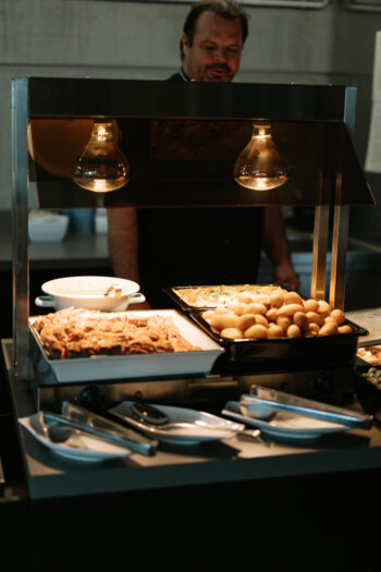 Koch steht hinter dem Buffet